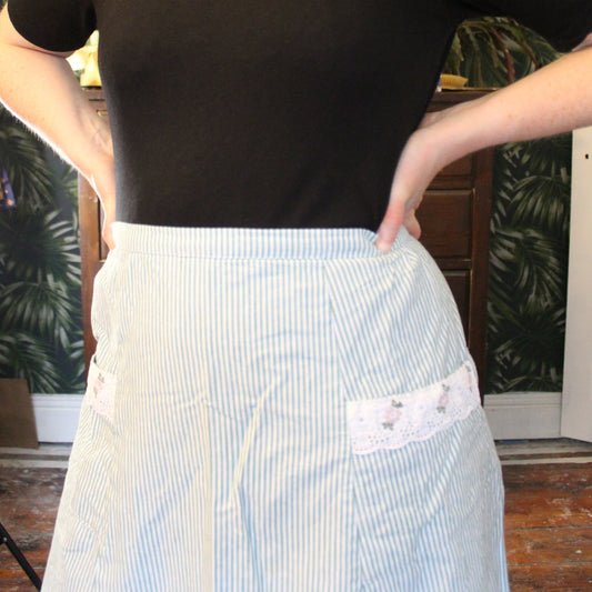 Green and white striped half apron with white trim