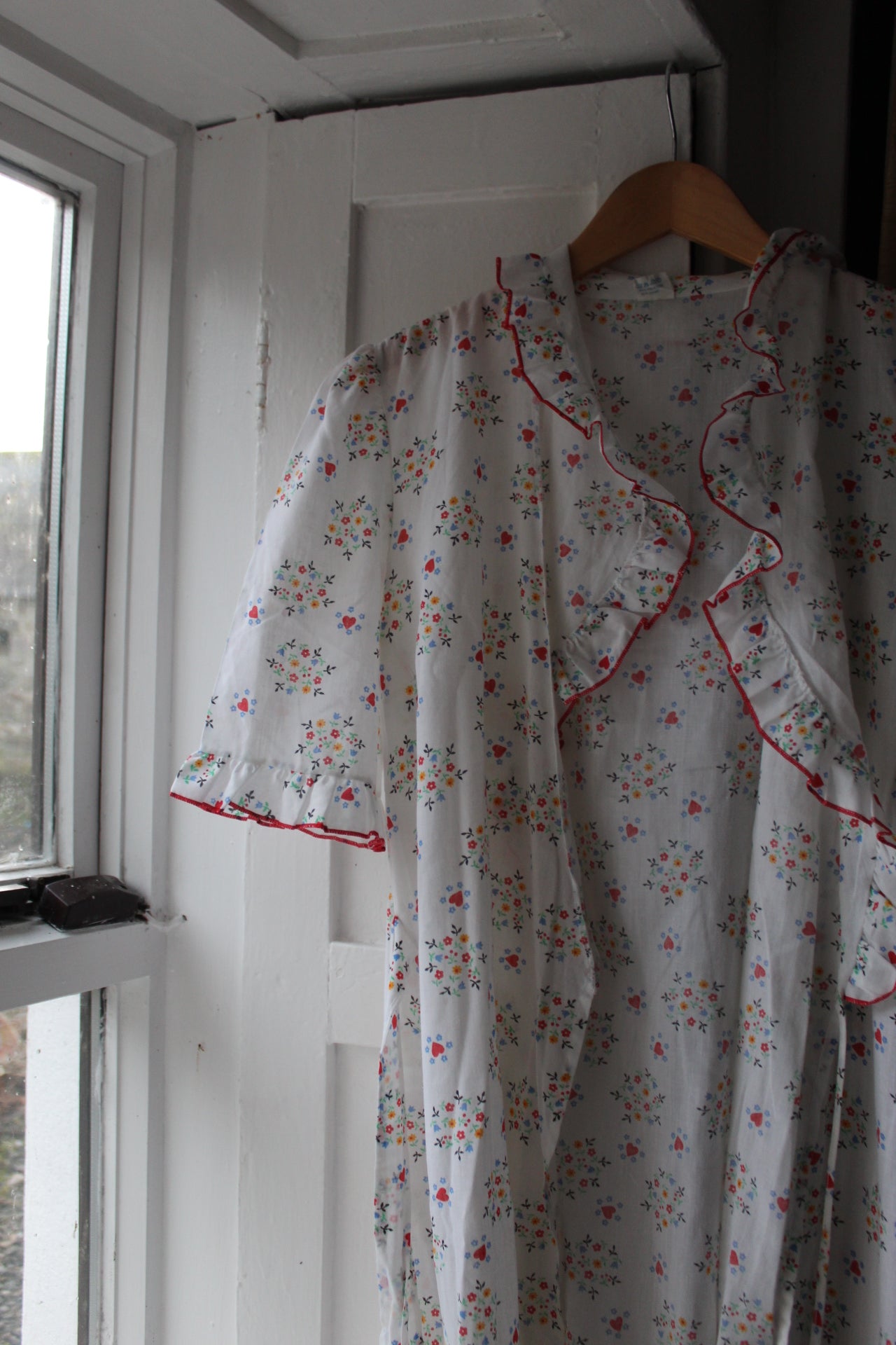 White robe with red heart and flower design