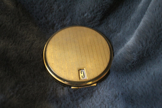Round, gold Stratton compact