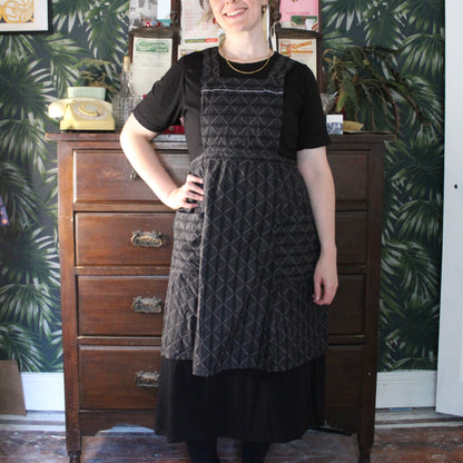 Black apron with salt white geometric embroidered pattern
