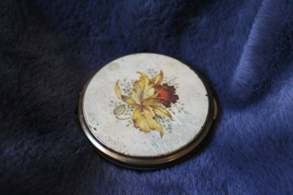 Round gold compact with floral details